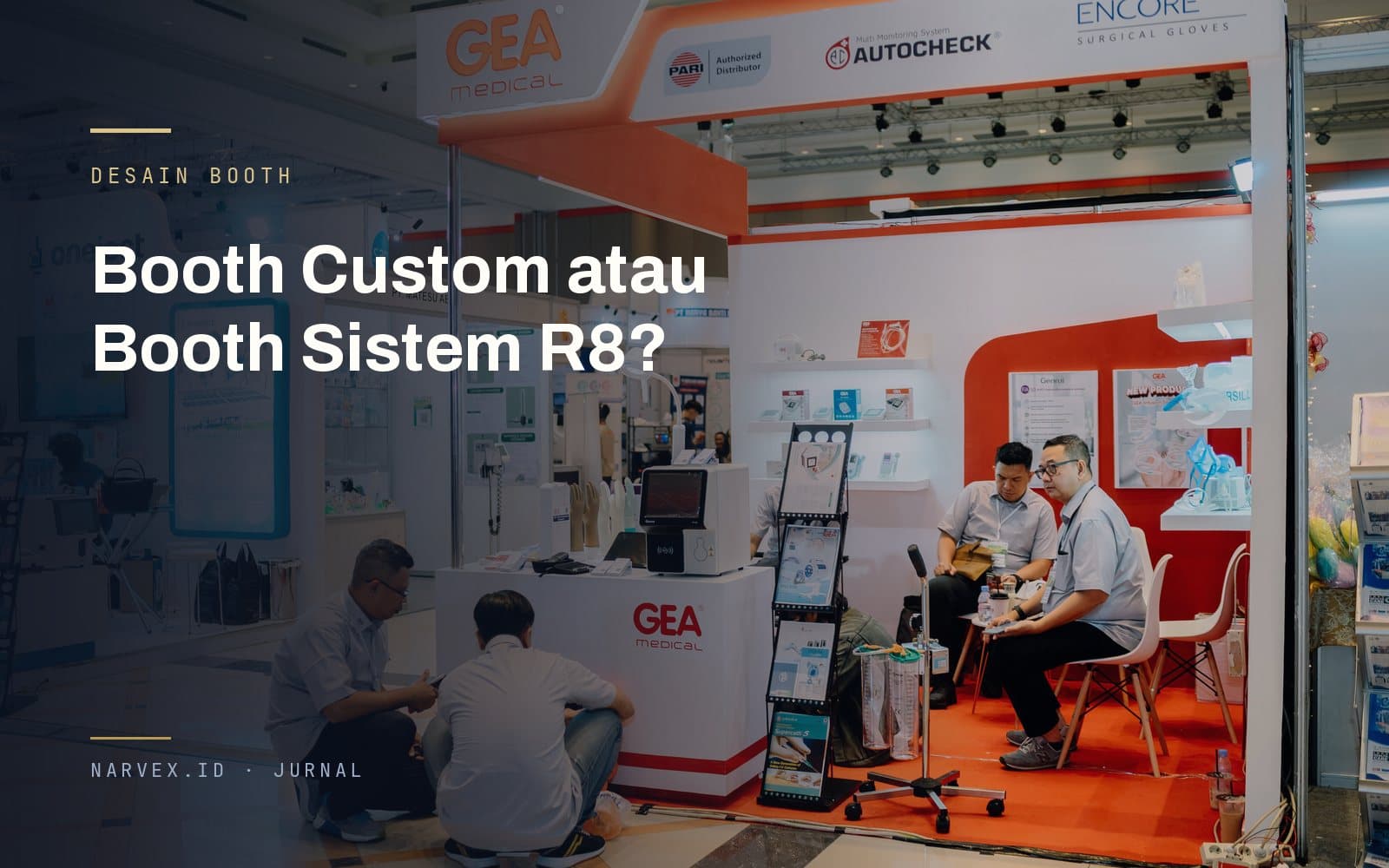 Booth pameran GEA Medical dengan panel putih dan aksen oranye, dua staf berdiskusi di dalamnya